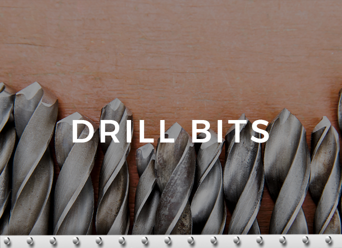 Assorted metal drill bits against wooden background.